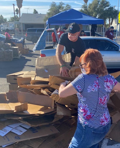 Ken Bahl and CBC co-worker breaking down boxes that contained donated food.