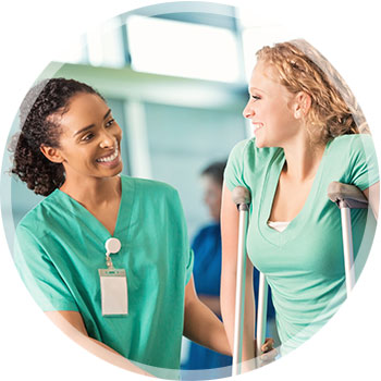 Photo of a female employee on crutches being assisted by a nurse or physical therapist